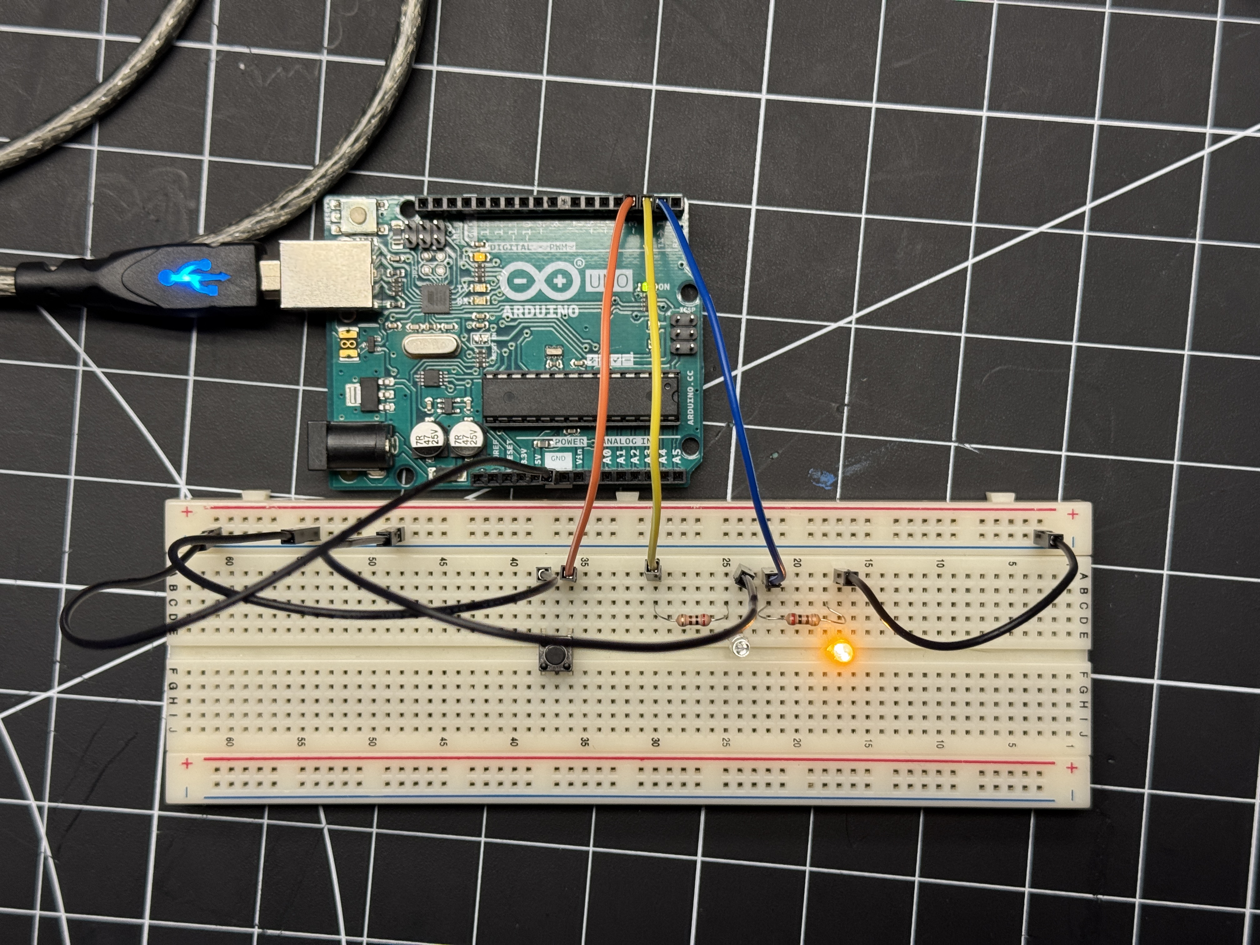 Top-down view of my circuit, consisting of 2 LED's, 2 resistors, and 1 button (as well as a bunch of wires)