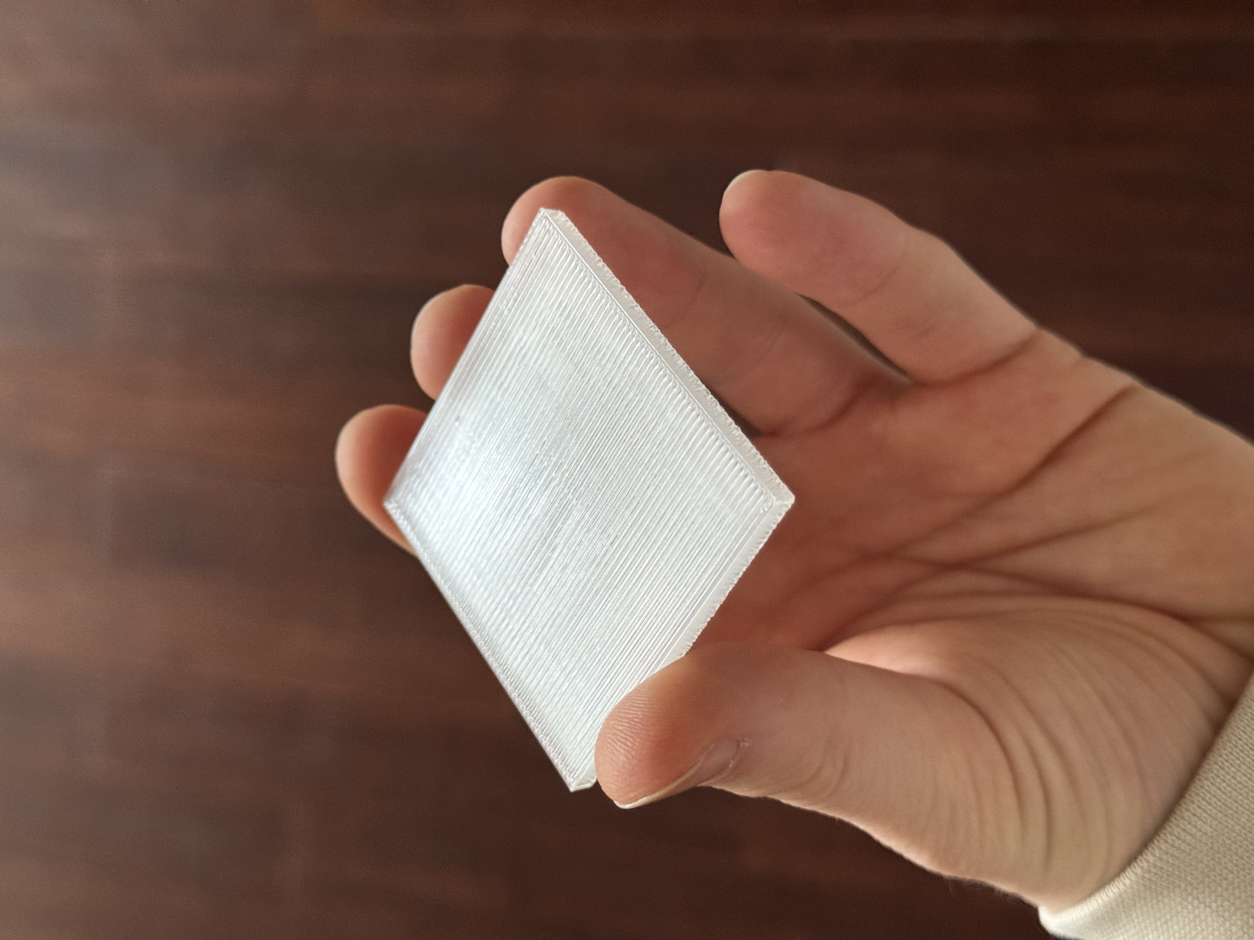 After drying the filament and switching to the recommended settings, the second test print came out flawless. It's not entirely translucent because my buildplate is textured, but it works for my project just fine.